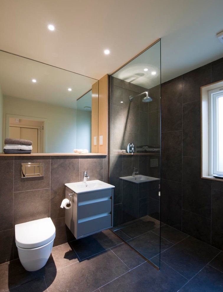 Inspiration för ett mellanstort funkis badrum, med ett väggmonterat handfat, träbänkskiva, en öppen dusch, en vägghängd toalettstol, brun kakel, porslinskakel, vita väggar och klinkergolv i porslin