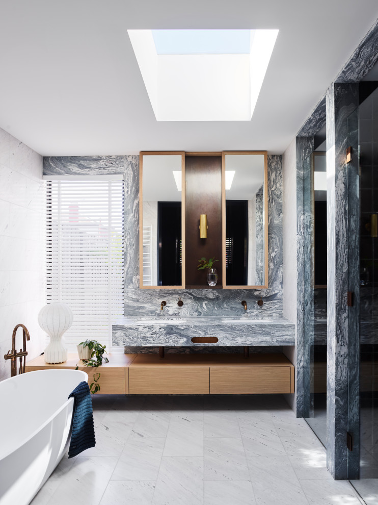 Réalisation d'une grande salle de bain principale design en bois clair avec un placard à porte plane, une baignoire indépendante, un carrelage gris, un mur blanc, un lavabo posé, un sol beige, un plan de toilette gris, meuble double vasque et meuble-lavabo suspendu.