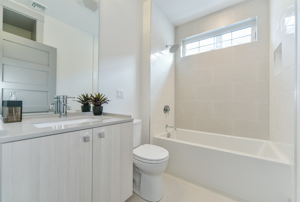 Foto på ett mellanstort funkis badrum med dusch, med släta luckor, grå skåp, ett badkar i en alkov, en dusch/badkar-kombination, en toalettstol med separat cisternkåpa, grå kakel, keramikplattor, vita väggar, klinkergolv i keramik, ett nedsänkt handfat och bänkskiva i akrylsten