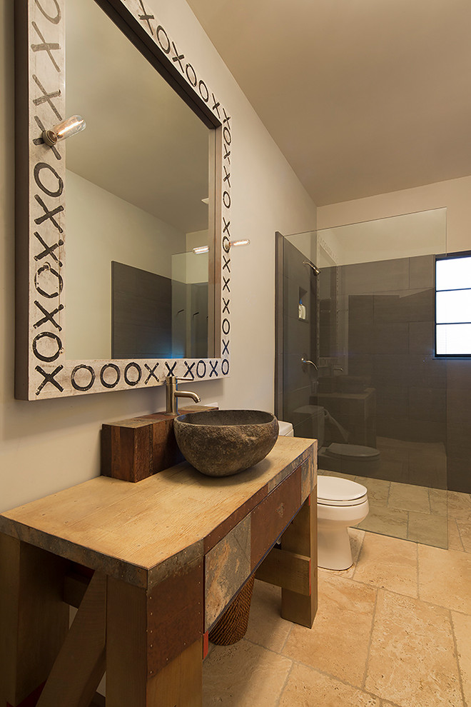 Стильный дизайн: ванная комната среднего размера в стиле кантри с раздельным унитазом, бежевой плиткой, каменной плиткой, бежевыми стенами, полом из известняка, душевой кабиной, настольной раковиной и столешницей из дерева - последний тренд