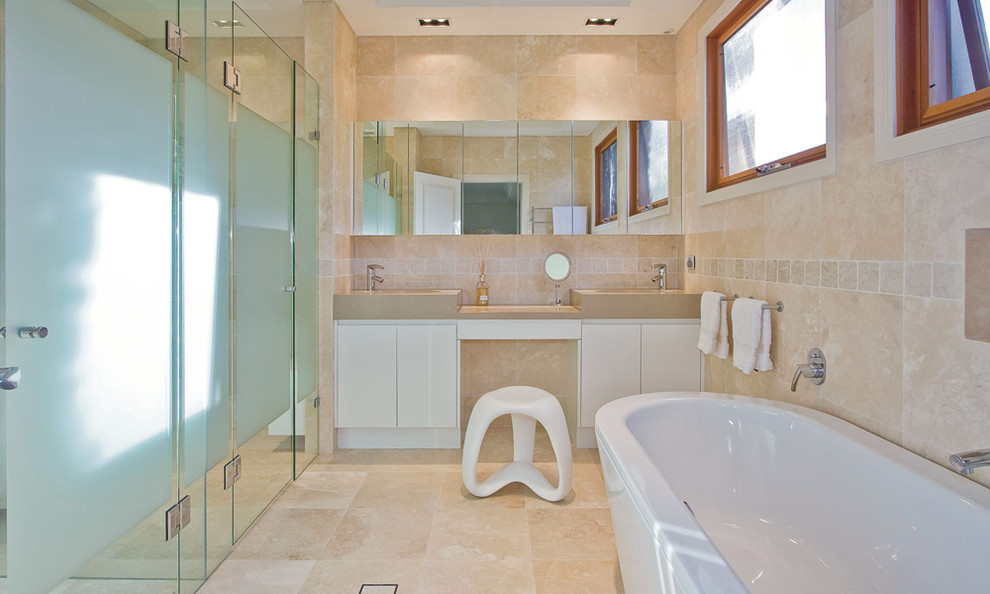 Idéer för ett modernt badrum, med ett integrerad handfat, släta luckor, vita skåp, ett fristående badkar, en kantlös dusch och beige kakel