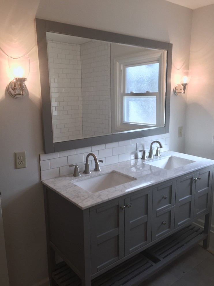 Klassisk inredning av ett mellanstort vit vitt badrum, med möbel-liknande, grå skåp, ett badkar i en alkov, en dusch/badkar-kombination, vit kakel, tunnelbanekakel, grå väggar, ett undermonterad handfat och bänkskiva i kvartsit