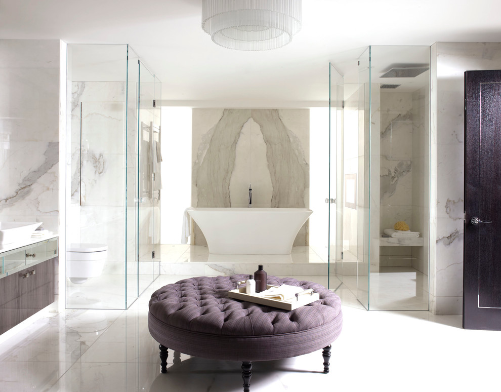 Freestanding bathtub - contemporary white tile and stone slab freestanding bathtub idea in London