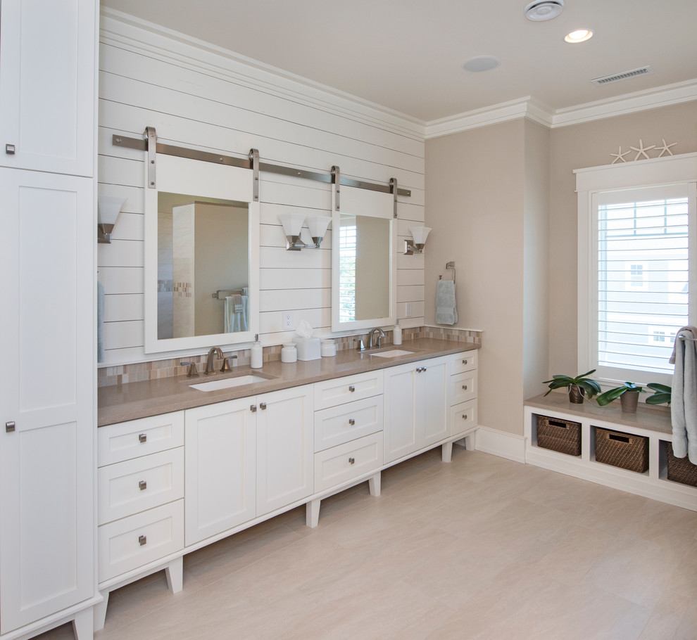 Cette image montre une salle de bain marine avec un placard à porte shaker, des portes de placard blanches, un mur beige, un lavabo encastré, un sol beige et un plan de toilette marron.