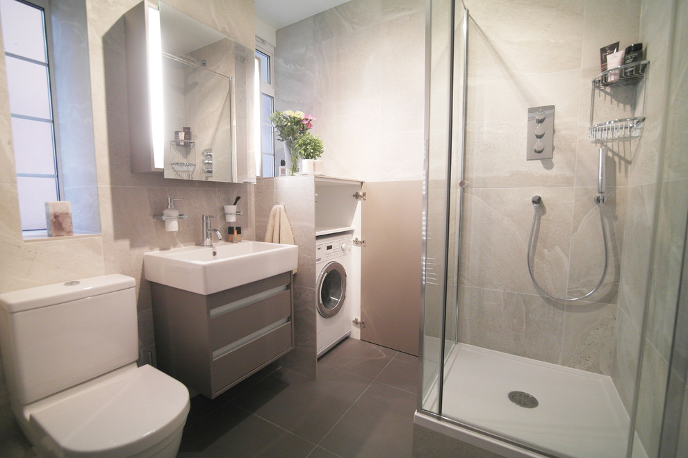 Foto di una stanza da bagno con doccia contemporanea di medie dimensioni con ante di vetro, ante grigie, doccia ad angolo, WC monopezzo, piastrelle grigie, piastrelle in gres porcellanato e lavabo sospeso