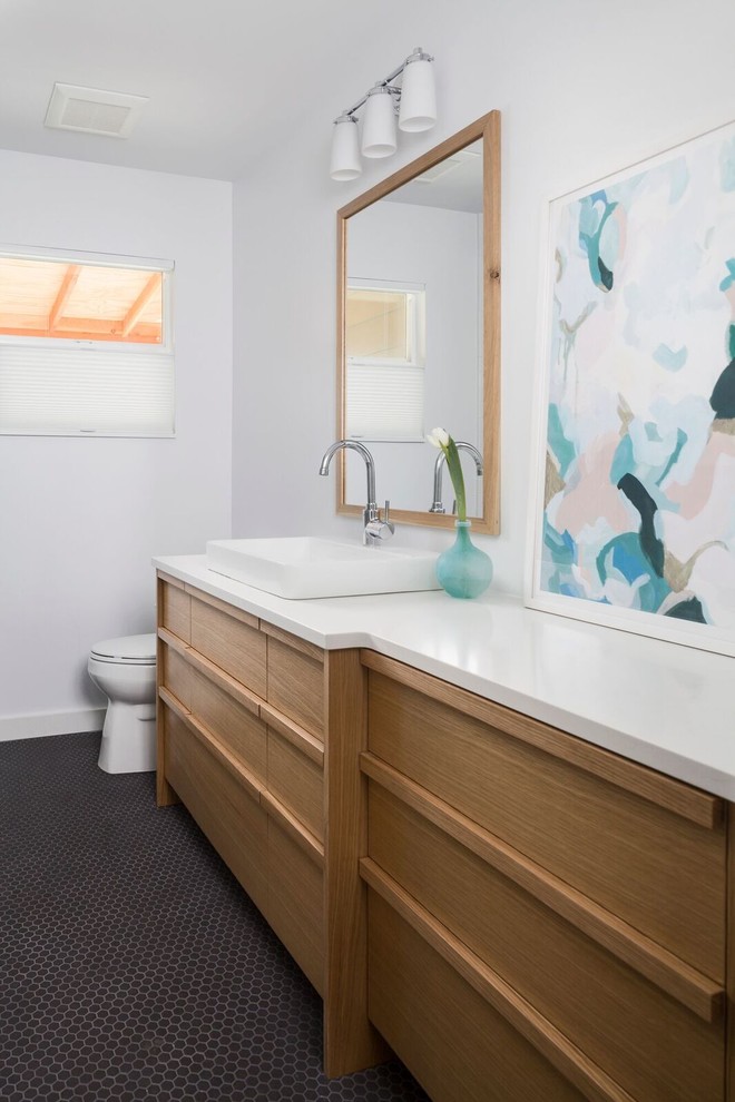Aménagement d'une salle de bain rétro en bois clair de taille moyenne avec WC à poser, un carrelage noir, des carreaux de porcelaine, un mur blanc, un sol en carrelage de porcelaine, une vasque et un plan de toilette en quartz modifié.