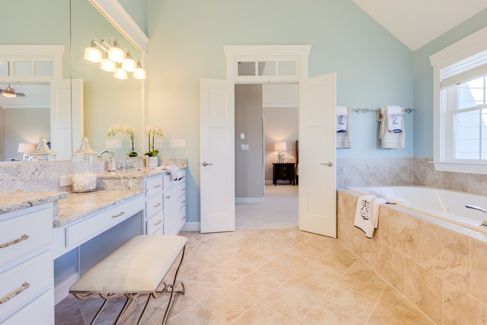 Inspiration for a large coastal master beige tile and porcelain tile ceramic tile bathroom remodel in Other with an undermount sink, white cabinets, quartz countertops, a two-piece toilet, beige walls and raised-panel cabinets