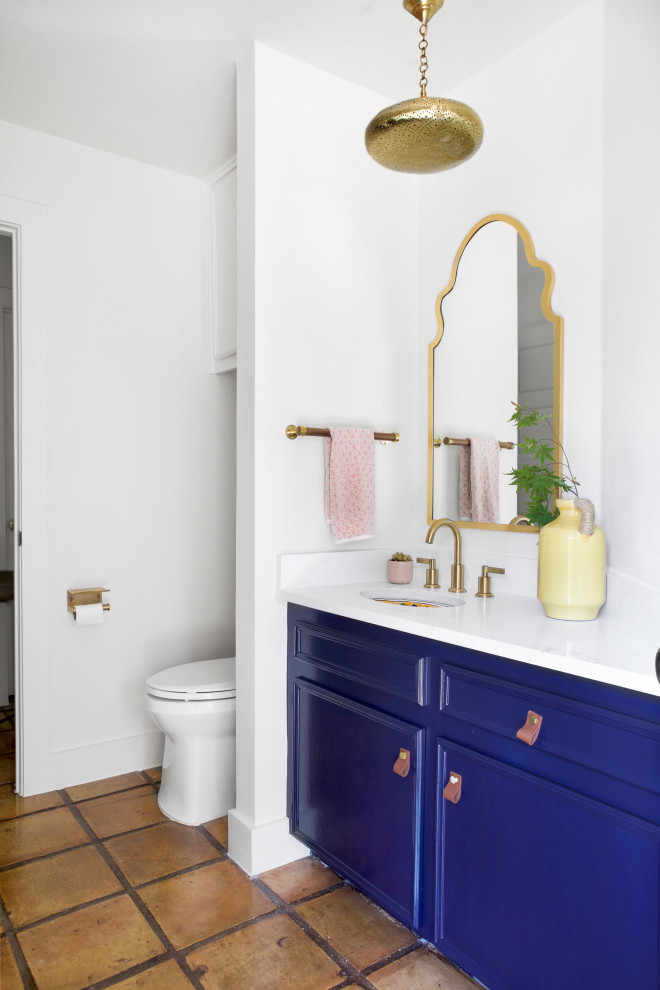 Réalisation d'une salle de bain bohème avec des portes de placard bleues, un mur blanc, un lavabo encastré, un plan de toilette en quartz modifié, un plan de toilette blanc, meuble simple vasque et meuble-lavabo encastré.