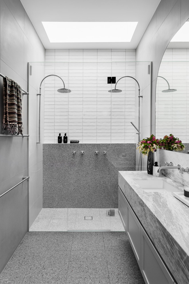 Aménagement d'une salle de bain contemporaine avec un placard à porte shaker, des portes de placard grises, une douche double, un carrelage gris, un carrelage blanc, un lavabo encastré, un sol gris, une cabine de douche à porte battante et un plan de toilette gris.