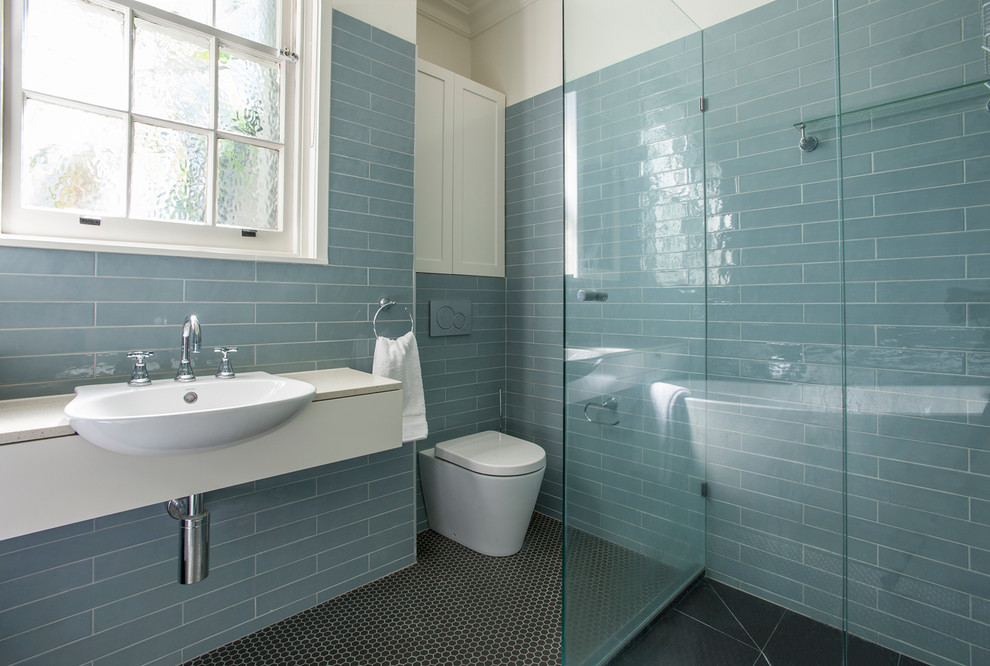 Idée de décoration pour une salle de bain principale craftsman de taille moyenne avec un placard à porte plane, des portes de placard blanches, un carrelage bleu, des carreaux de porcelaine et un plan de toilette beige.