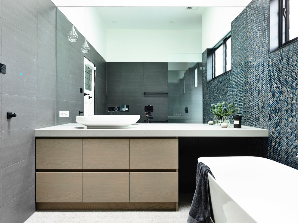Inspiration for a large contemporary ensuite bathroom in Melbourne with light wood cabinets, a freestanding bath, a walk-in shower, blue tiles, mosaic tiles and engineered stone worktops.