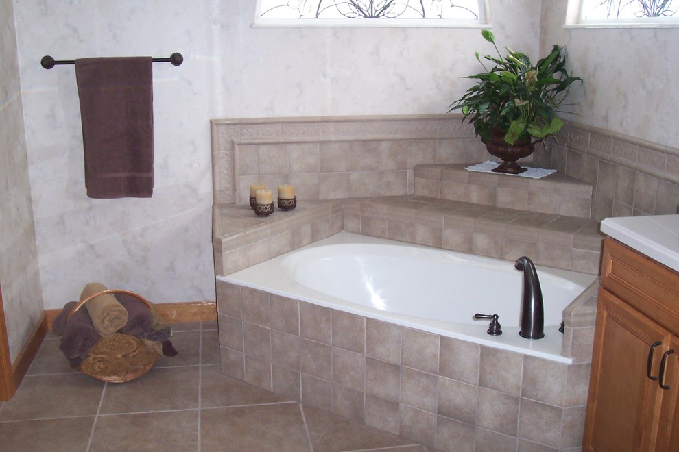 Inspiration pour une salle de bain principale en bois brun de taille moyenne avec un placard avec porte à panneau surélevé, une baignoire encastrée, un carrelage beige, des carreaux de céramique, un mur beige, un sol en carrelage de céramique, un plan de toilette en carrelage et un sol beige.