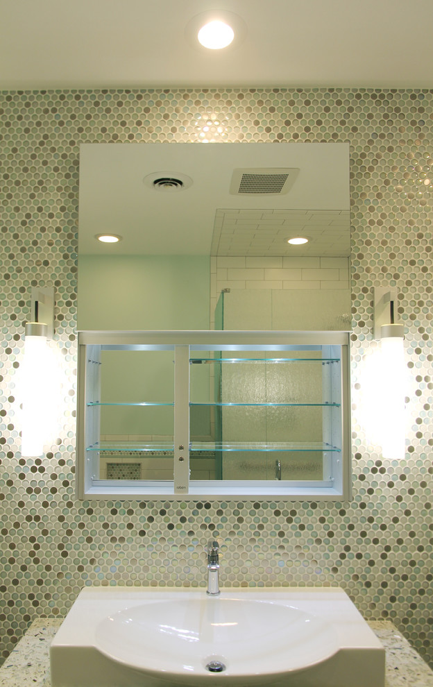 Cette image montre une douche en alcôve design de taille moyenne pour enfant avec une vasque, un plan de toilette en verre recyclé, une baignoire encastrée, WC suspendus et un carrelage multicolore.