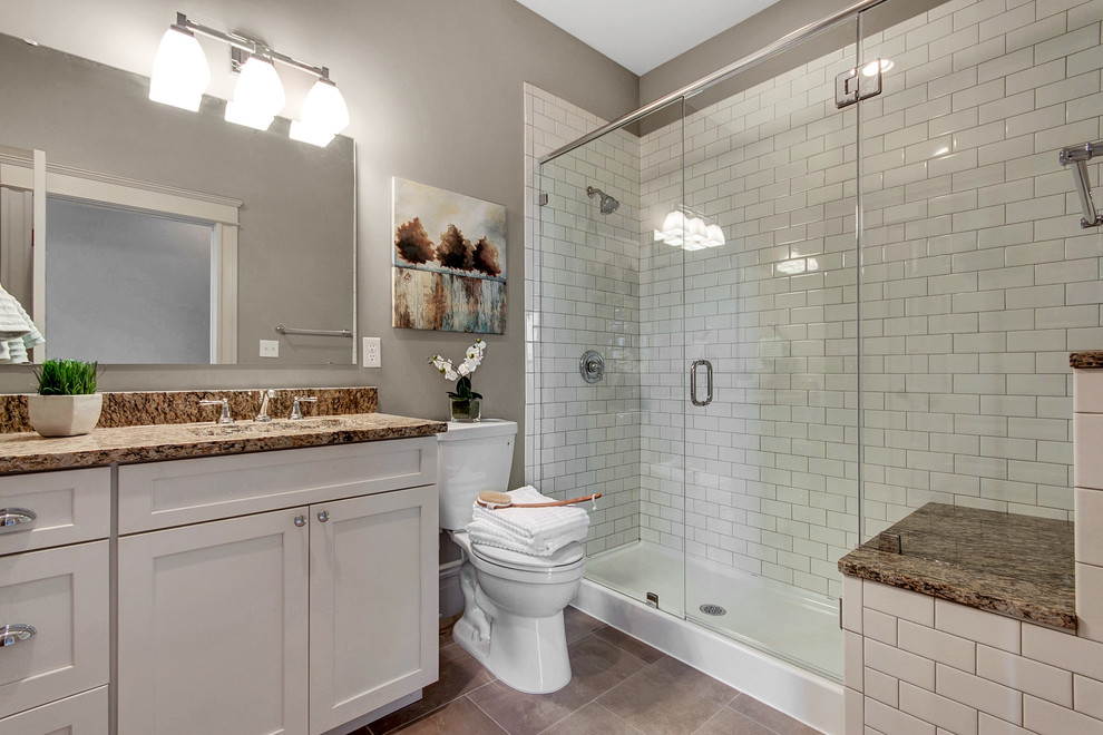Exemple d'une douche en alcôve chic avec un placard à porte shaker, des portes de placard blanches, WC séparés, un carrelage blanc, un carrelage métro, un mur beige, un lavabo encastré et un plan de toilette en granite.