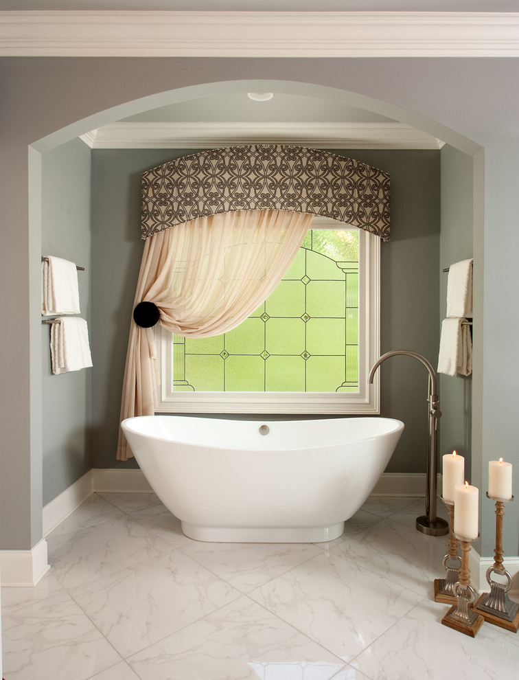 Immagine di una grande stanza da bagno padronale tradizionale con ante grigie, vasca freestanding, piastrelle bianche, piastrelle di vetro, pareti grigie, lavabo sottopiano e top in granito