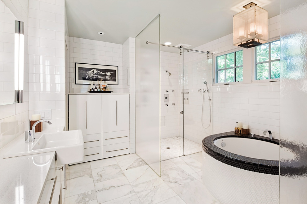 Design ideas for a contemporary bathroom in Raleigh with a wall-mounted sink, flat-panel cabinets, white cabinets, an alcove shower, white tiles, white walls and a submerged bath.