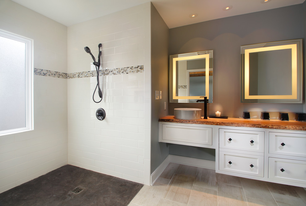 Exempel på ett mellanstort modernt en-suite badrum, med möbel-liknande, vita skåp, en kantlös dusch, vit kakel, keramikplattor, grå väggar, klinkergolv i porslin, ett fristående handfat och träbänkskiva