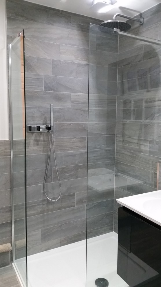Inspiration för mellanstora moderna badrum, med ett väggmonterat handfat, ett fristående badkar, en öppen dusch, en vägghängd toalettstol, grå kakel, porslinskakel, vita väggar och klinkergolv i porslin