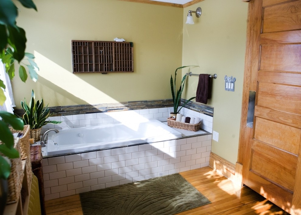 Drop-in bathtub - mid-sized 3/4 white tile and subway tile light wood floor drop-in bathtub idea in Minneapolis with an integrated sink, shaker cabinets, dark wood cabinets and green walls