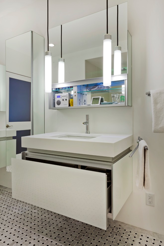 This is an example of a medium sized contemporary ensuite bathroom in Minneapolis with a submerged sink, glass-front cabinets, white cabinets, solid surface worktops, a freestanding bath, an alcove shower, a one-piece toilet, multi-coloured tiles, stone tiles, white walls and marble flooring.