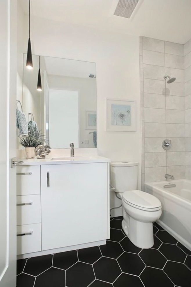 Inspiration for a medium sized contemporary ensuite bathroom in Denver with flat-panel cabinets, white cabinets, a freestanding bath, a shower/bath combination, a one-piece toilet, white tiles, ceramic tiles, white walls, pebble tile flooring, a submerged sink, engineered stone worktops, black floors and an open shower.