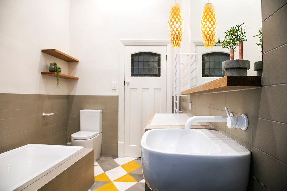 Источник вдохновения для домашнего уюта: главная ванная комната в современном стиле с фасадами островного типа, фасадами цвета дерева среднего тона, накладной ванной, душем в нише, желтой плиткой, керамической плиткой, белыми стенами, полом из керамогранита и подвесной раковиной