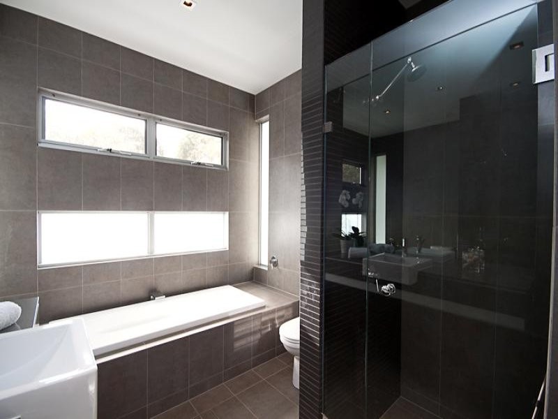 На фото: главная ванная комната среднего размера в современном стиле с накладной ванной, душем в нише, серой плиткой и серыми стенами с