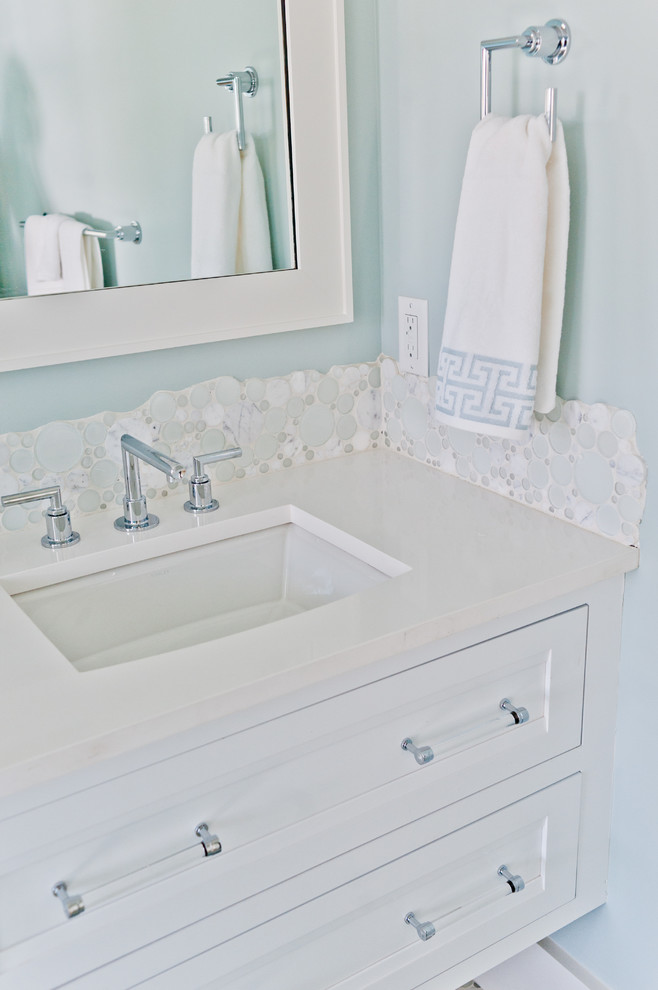 Diseño de cuarto de baño costero de tamaño medio con armarios con rebordes decorativos, puertas de armario blancas, baldosas y/o azulejos blancos, paredes azules y encimera de mármol