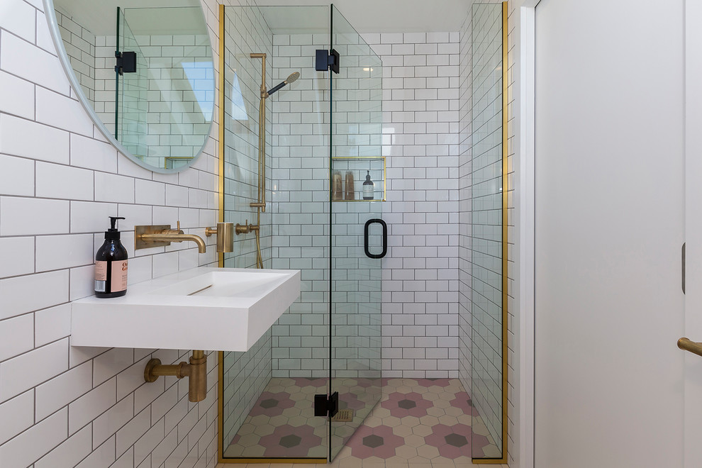 Idée de décoration pour une salle d'eau design avec une douche à l'italienne, un carrelage blanc, un carrelage métro, un mur blanc, un lavabo suspendu, un sol multicolore et une cabine de douche à porte battante.