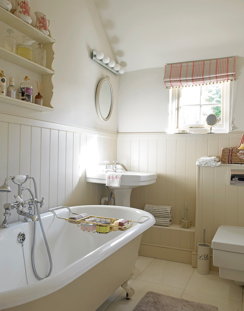 Cette photo montre une salle de bain romantique avec une baignoire sur pieds, WC suspendus, un mur beige et un lavabo de ferme.