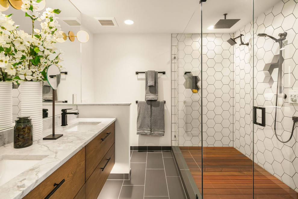 Cette photo montre une salle de bain principale tendance en bois brun avec un carrelage blanc, des carreaux de céramique, un plan de toilette en granite, une cabine de douche à porte battante, un plan de toilette gris, un placard à porte plane, une douche double, un mur blanc, un lavabo encastré et un sol gris.