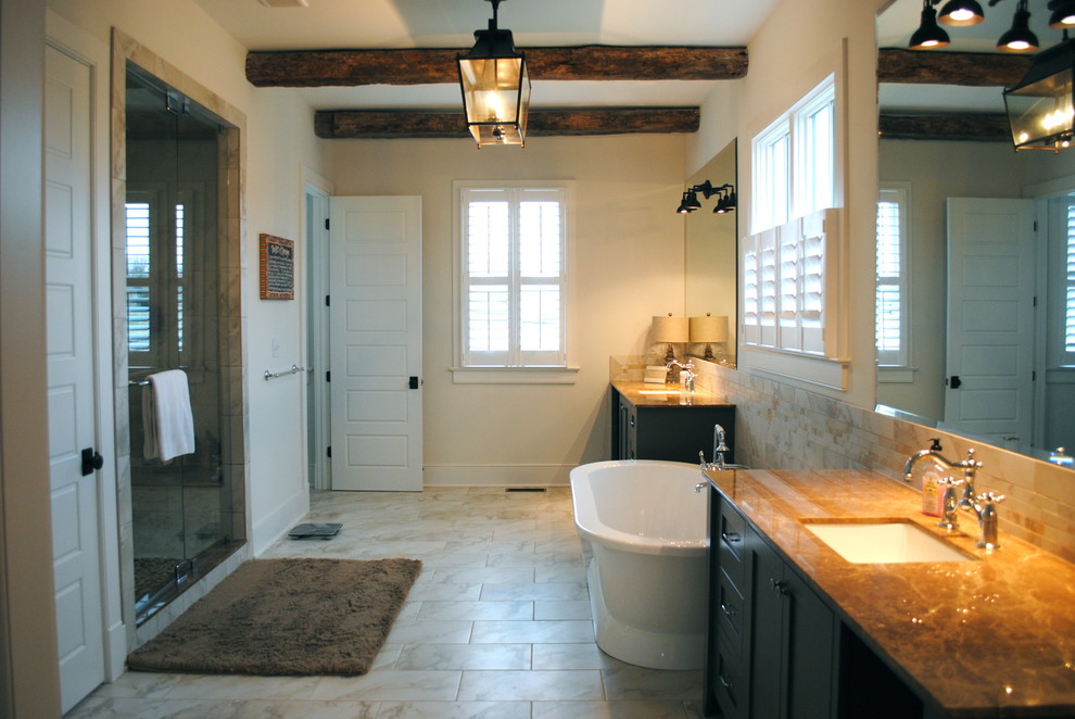 Foto di una stanza da bagno country con lavabo sottopiano, consolle stile comò, ante grigie, top in marmo, vasca freestanding, piastrelle bianche e piastrelle in gres porcellanato