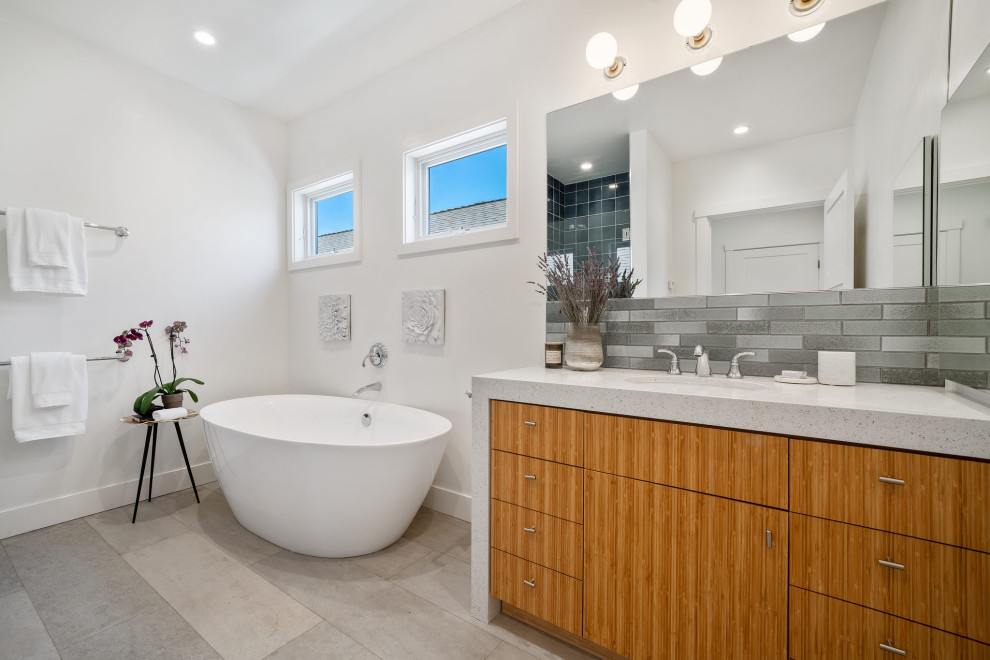 Modernes Badezimmer mit flächenbündigen Schrankfronten, hellbraunen Holzschränken, freistehender Badewanne, grauen Fliesen, weißer Wandfarbe, Unterbauwaschbecken, grauem Boden, weißer Waschtischplatte und Einzelwaschbecken in San Francisco