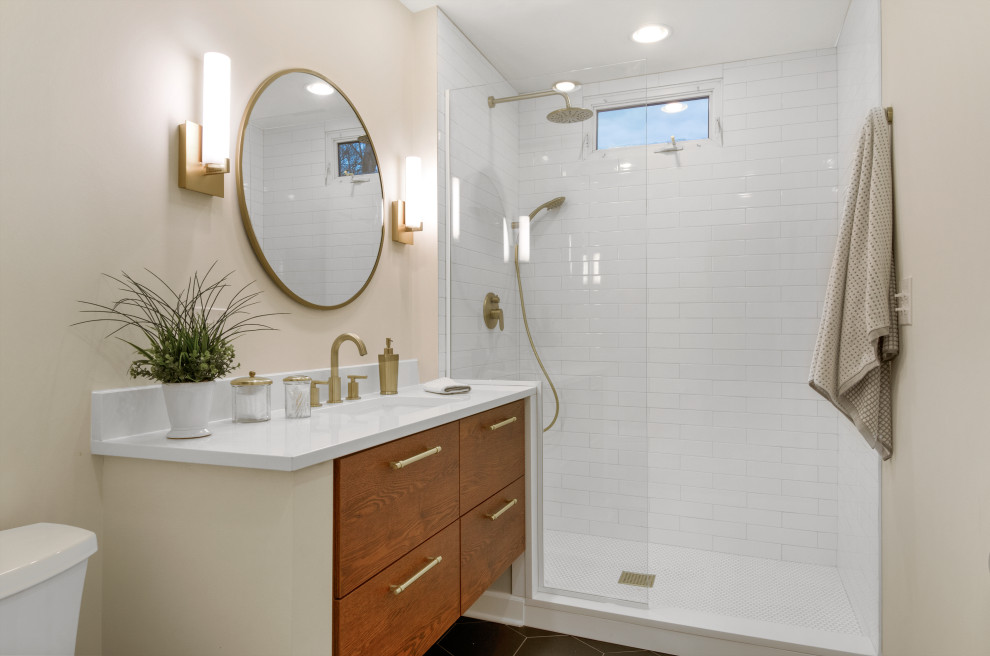 Пример оригинального дизайна: маленькая главная ванная комната в стиле кантри с плоскими фасадами, фасадами цвета дерева среднего тона, открытым душем, унитазом-моноблоком, белой плиткой, керамической плиткой, серыми стенами, полом из керамической плитки, врезной раковиной, столешницей из искусственного кварца, черным полом, открытым душем, белой столешницей, тумбой под одну раковину и подвесной тумбой для на участке и в саду