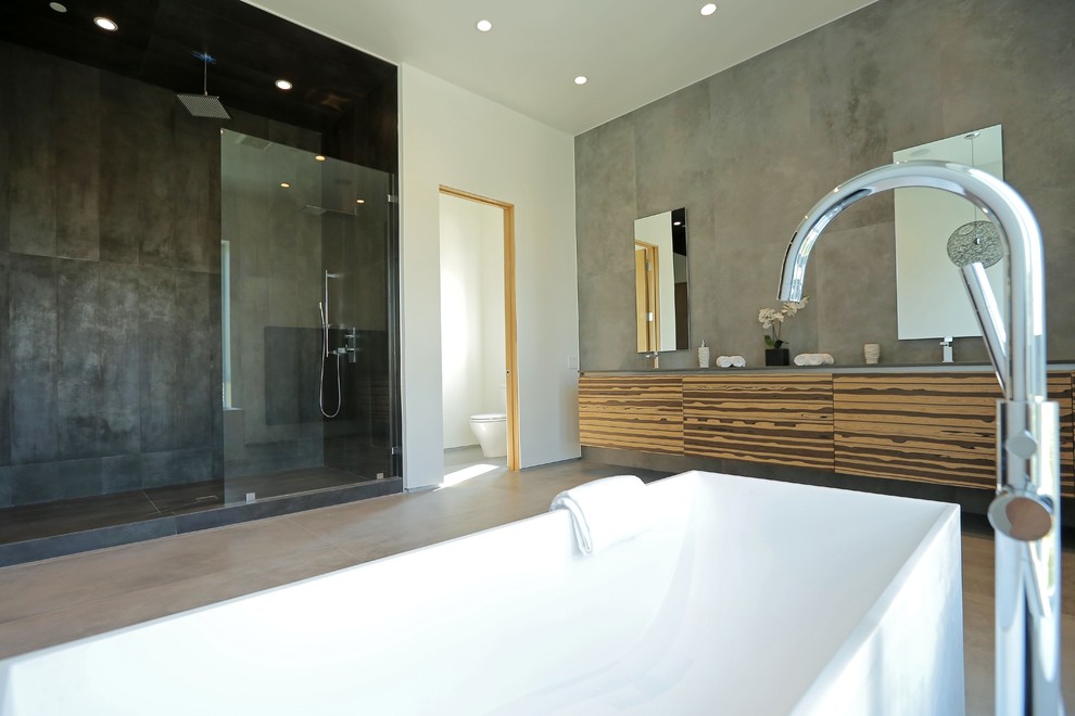 Стильный дизайн: большая главная ванная комната в современном стиле с плоскими фасадами, искусственно-состаренными фасадами, столешницей из гранита, отдельно стоящей ванной, открытым душем, унитазом-моноблоком, черной плиткой, плиткой из листового камня, серыми стенами и бетонным полом - последний тренд