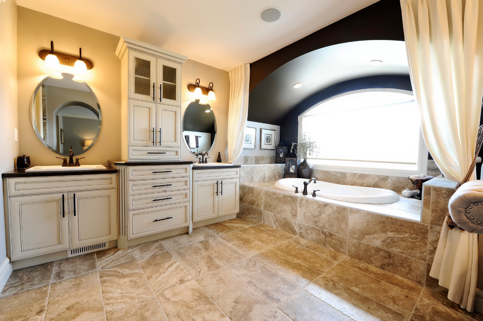 This is an example of a traditional bathroom in Edmonton with a built-in sink, recessed-panel cabinets, beige cabinets, a built-in bath and beige tiles.