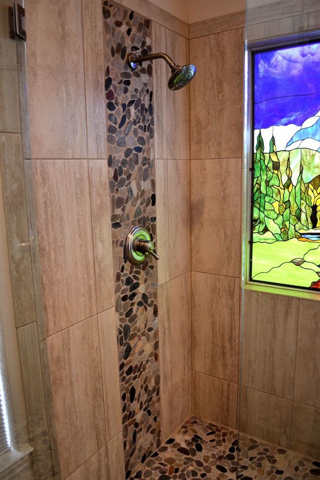 Photo of a small rustic ensuite bathroom in Austin with shaker cabinets, medium wood cabinets, a corner shower, pebble tiles, white walls, laminate floors, a submerged sink, laminate worktops, beige floors and a hinged door.