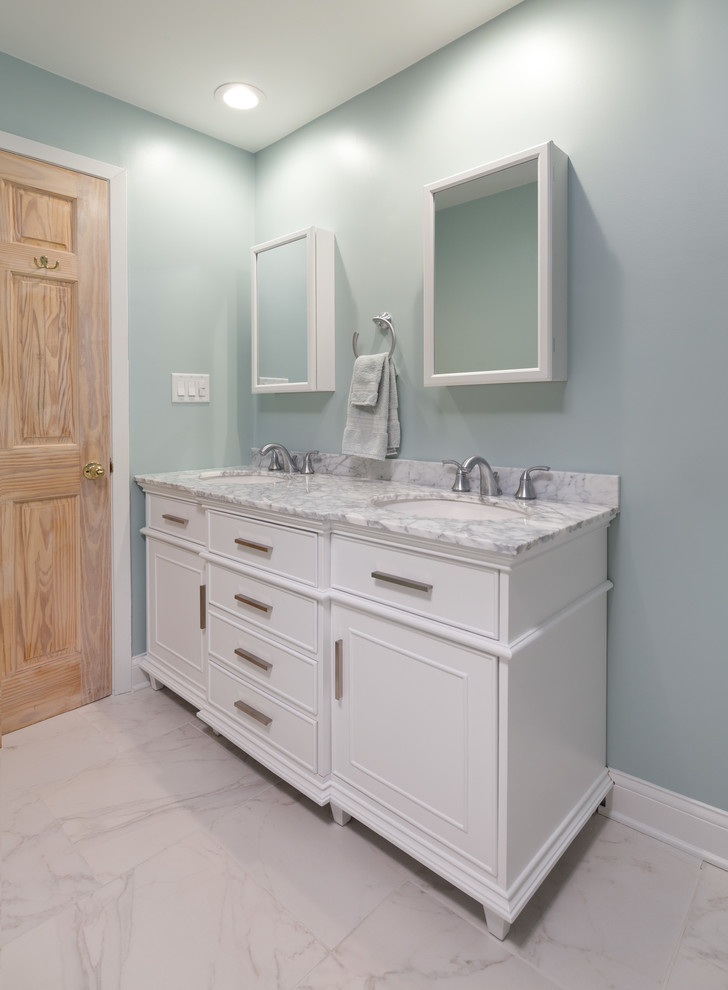 Inredning av ett modernt mellanstort en-suite badrum, med luckor med upphöjd panel, vita skåp, ett fristående badkar, en hörndusch, en toalettstol med hel cisternkåpa, vit kakel, stenhäll, vita väggar, marmorgolv, ett undermonterad handfat och marmorbänkskiva