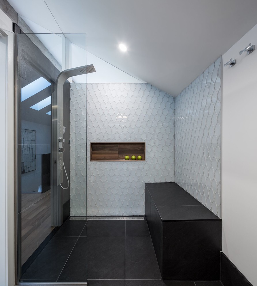 Example of a mid-sized trendy master gray tile, white tile and glass tile slate floor corner shower design in Toronto with white walls, open cabinets, light wood cabinets, a trough sink, wood countertops and a niche