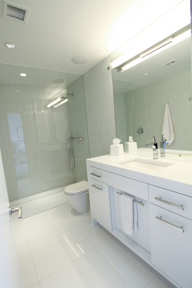 Esempio di una stanza da bagno con doccia design con lavabo sottopiano, ante bianche, doccia a filo pavimento, WC monopezzo, piastrelle grigie, pareti grigie e piastrelle a listelli
