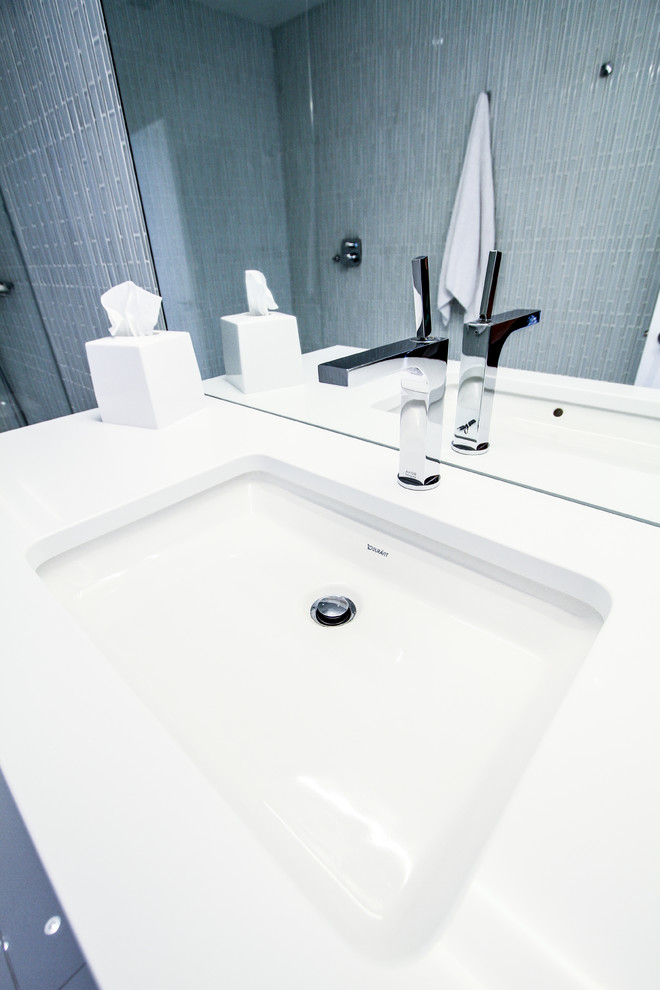 Cette image montre une salle d'eau design avec un lavabo encastré, des portes de placard blanches, une douche à l'italienne, WC à poser, un carrelage gris, un mur gris et des carreaux en allumettes.