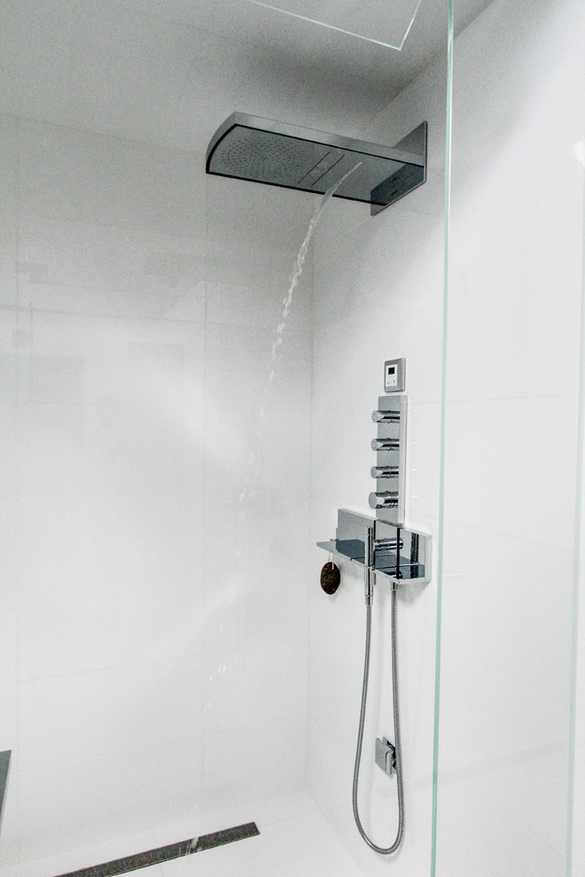 Пример оригинального дизайна: ванная комната в современном стиле с монолитной раковиной, душем без бортиков, унитазом-моноблоком, белой плиткой, белыми стенами и душевой кабиной