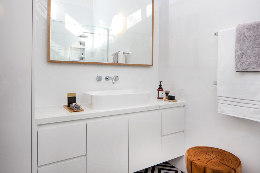 Идея дизайна: ванная комната среднего размера в современном стиле с фасадами островного типа, белыми фасадами, душем без бортиков, унитазом-моноблоком, черно-белой плиткой, керамической плиткой, белыми стенами, полом из керамогранита, душевой кабиной, настольной раковиной и столешницей из искусственного кварца