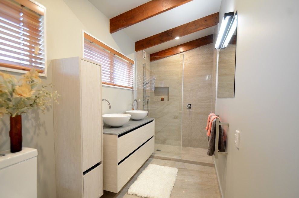 Idéer för mellanstora funkis grått en-suite badrum, med möbel-liknande, skåp i ljust trä, en öppen dusch, en toalettstol med hel cisternkåpa, grå kakel, keramikplattor, grå väggar, klinkergolv i keramik, ett fristående handfat, grått golv och med dusch som är öppen
