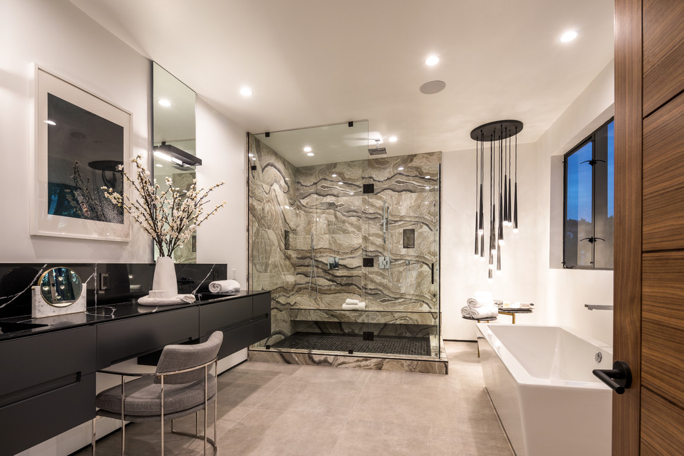 Cette photo montre une salle de bain tendance avec un placard à porte plane, des portes de placard noires, une baignoire indépendante, une douche d'angle, un carrelage beige, un mur blanc, un sol gris et une cabine de douche à porte battante.