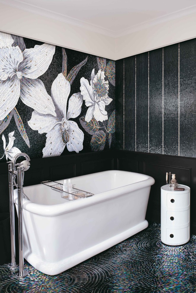 Bohemian bathroom in Bologna with a freestanding bath, black and white tiles and mosaic tiles.