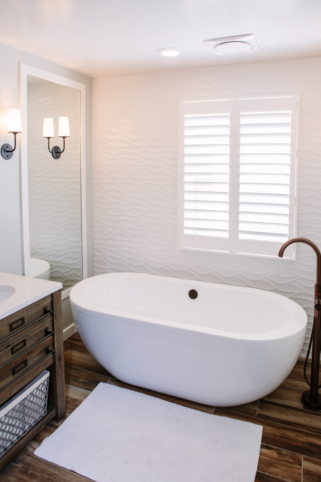 Example of a mid-sized farmhouse master white tile and ceramic tile porcelain tile and brown floor bathroom design in Denver with furniture-like cabinets, distressed cabinets, a one-piece toilet, gray walls, an undermount sink and quartz countertops