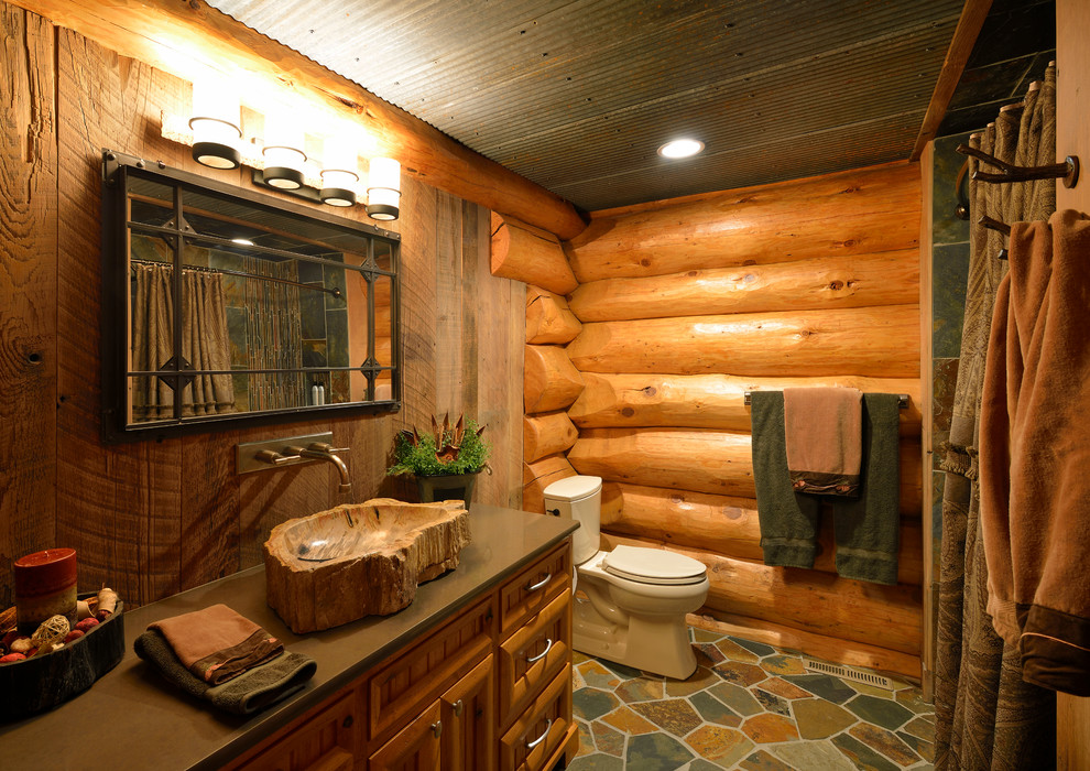 Foto på ett rustikt badrum, med ett fristående handfat, skåp i mellenmörkt trä, ett badkar i en alkov och en dusch/badkar-kombination