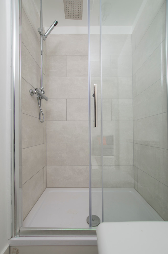 На фото: маленькая ванная комната в современном стиле с душем без бортиков, унитазом-моноблоком, серой плиткой, керамической плиткой, белыми стенами, полом из линолеума, душевой кабиной и накладной раковиной для на участке и в саду