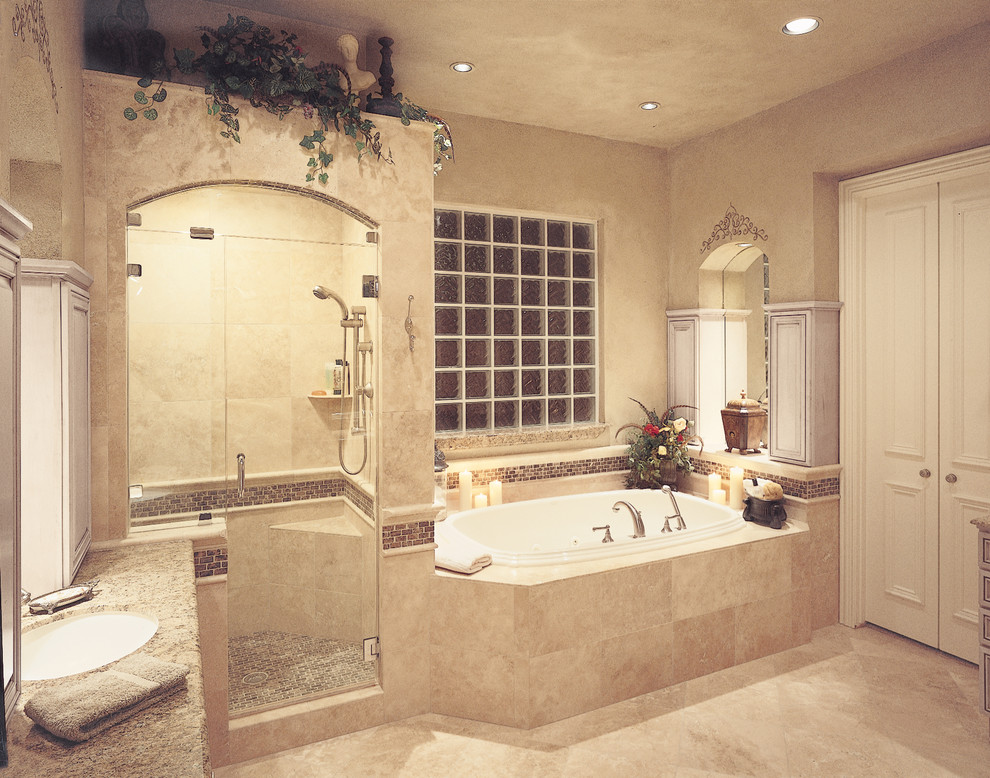 Cette image montre une grande salle de bain principale traditionnelle en bois clair avec un lavabo encastré, un placard avec porte à panneau surélevé, une baignoire posée, une douche d'angle et un mur beige.
